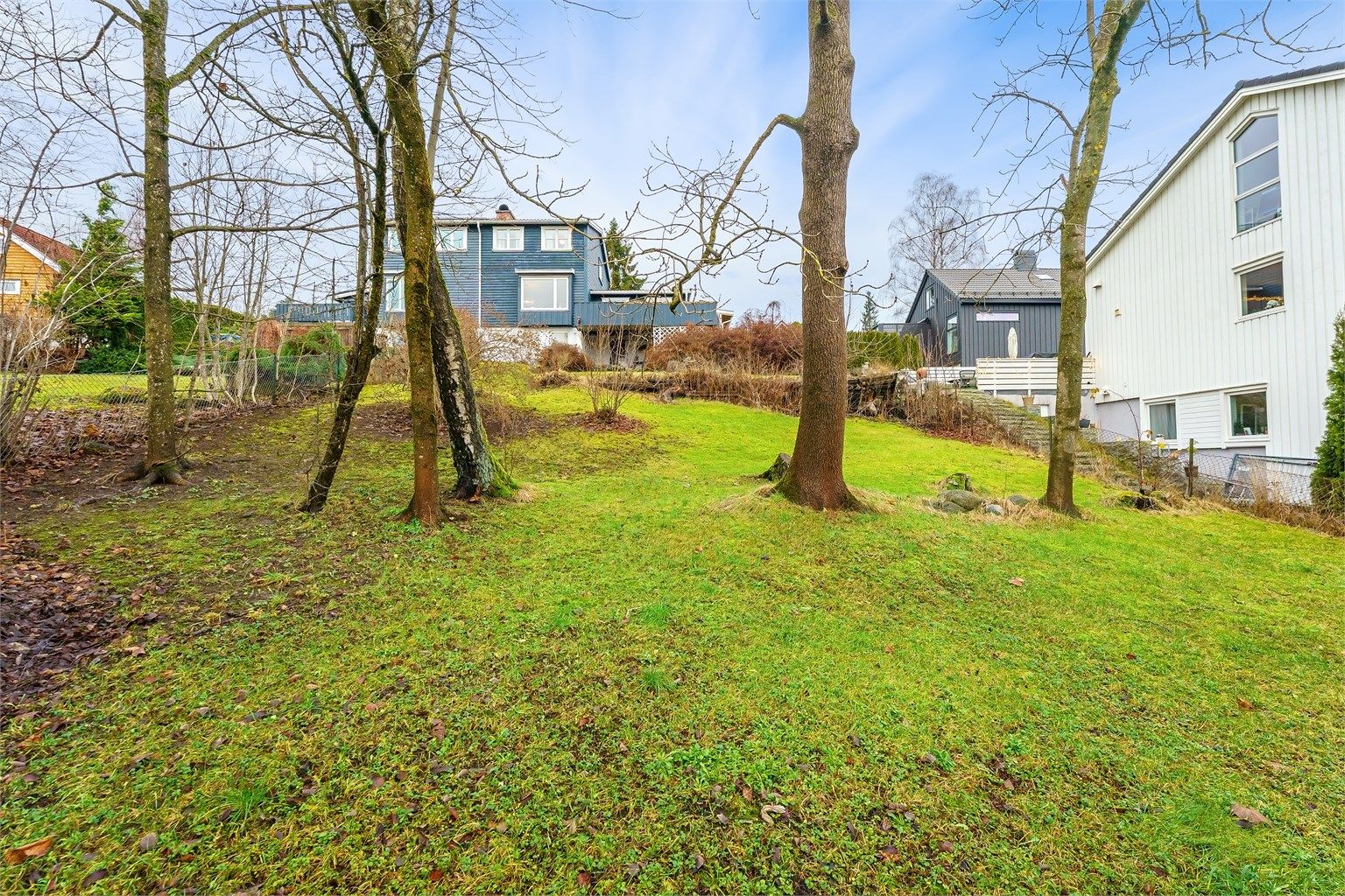 En veletablert og frodig hage som omkranser eiendommen.