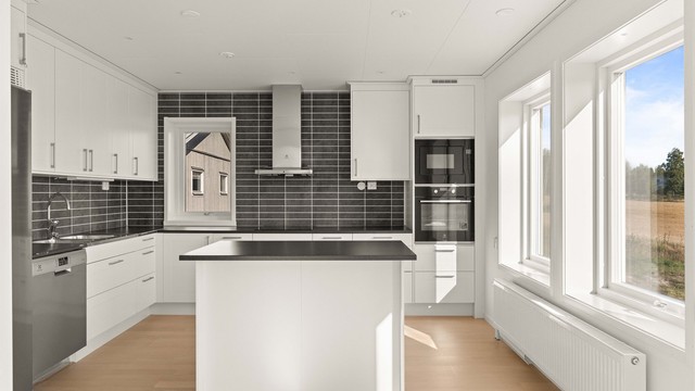 Kjøkken med hvite profilerte fronter, laminert benkeplate og hvitevarer fra Electrolux.