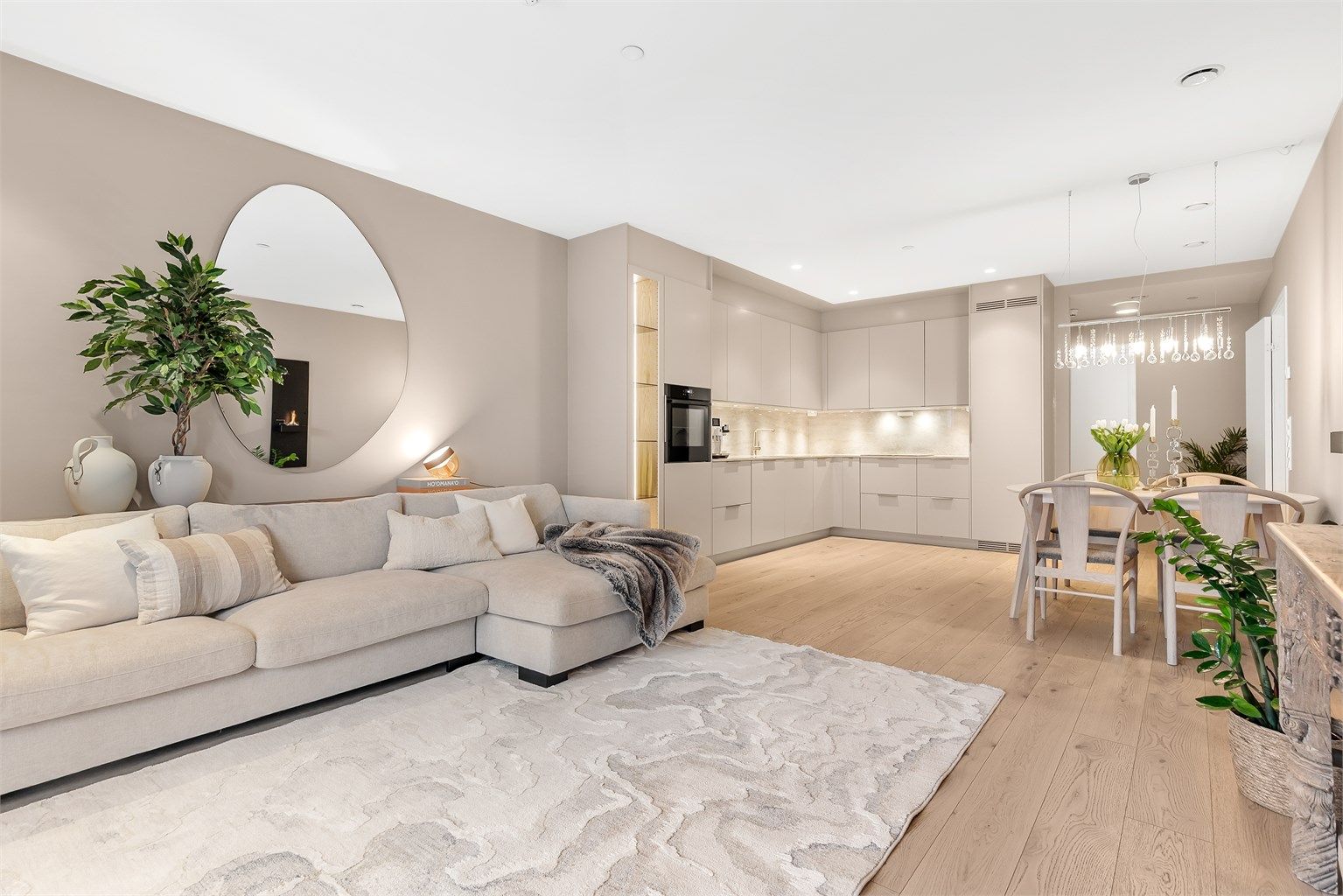 Lys og luftig stue med åpen løsning mot kjøkkenet, som skaper en sosial og innbydende atmosfære.