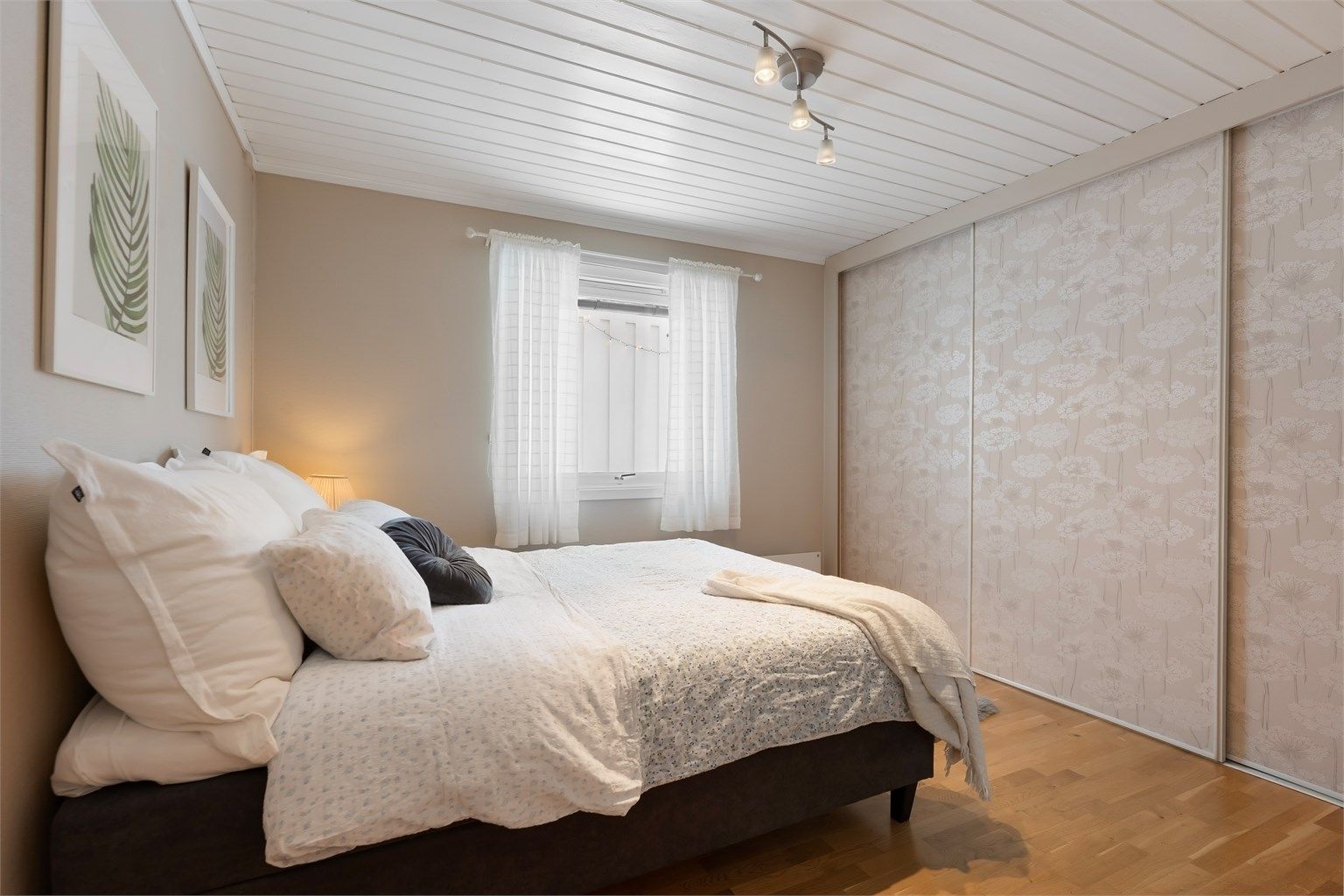 Her er det montert en romslig skyvedørsgarderobe for effektiv oppbevaring.