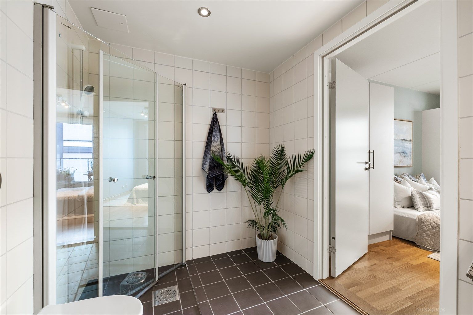 Badet har innfellbare dusjdører av glass og opplegg for vaskemaskin.