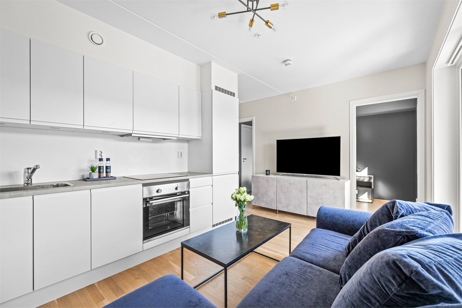 Kjøkkenet er en integrert del av oppholdsrommet, praktisk plassert for en sosial hverdag.