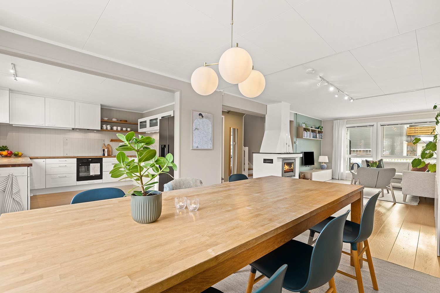 Den åpne løsningen mellom stue og kjøkken skaper en sosial og luftig atmosfære.