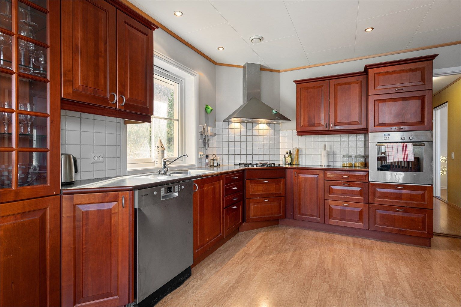 Kjøkkenet har fliser mellom benk og overskap, laminat benkeplate
med nedfelt 1-1/2 oppvaskkum. Det er kjøkkenventilator med avtrekk ut.