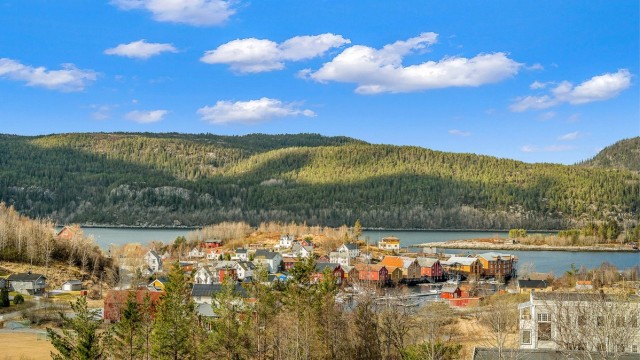 Nydelig utsikt over fjorden og den sjarmerende bryggerekka i Råkvåg – et idyllisk område med maritim atmosfære og vakre omgivelser.