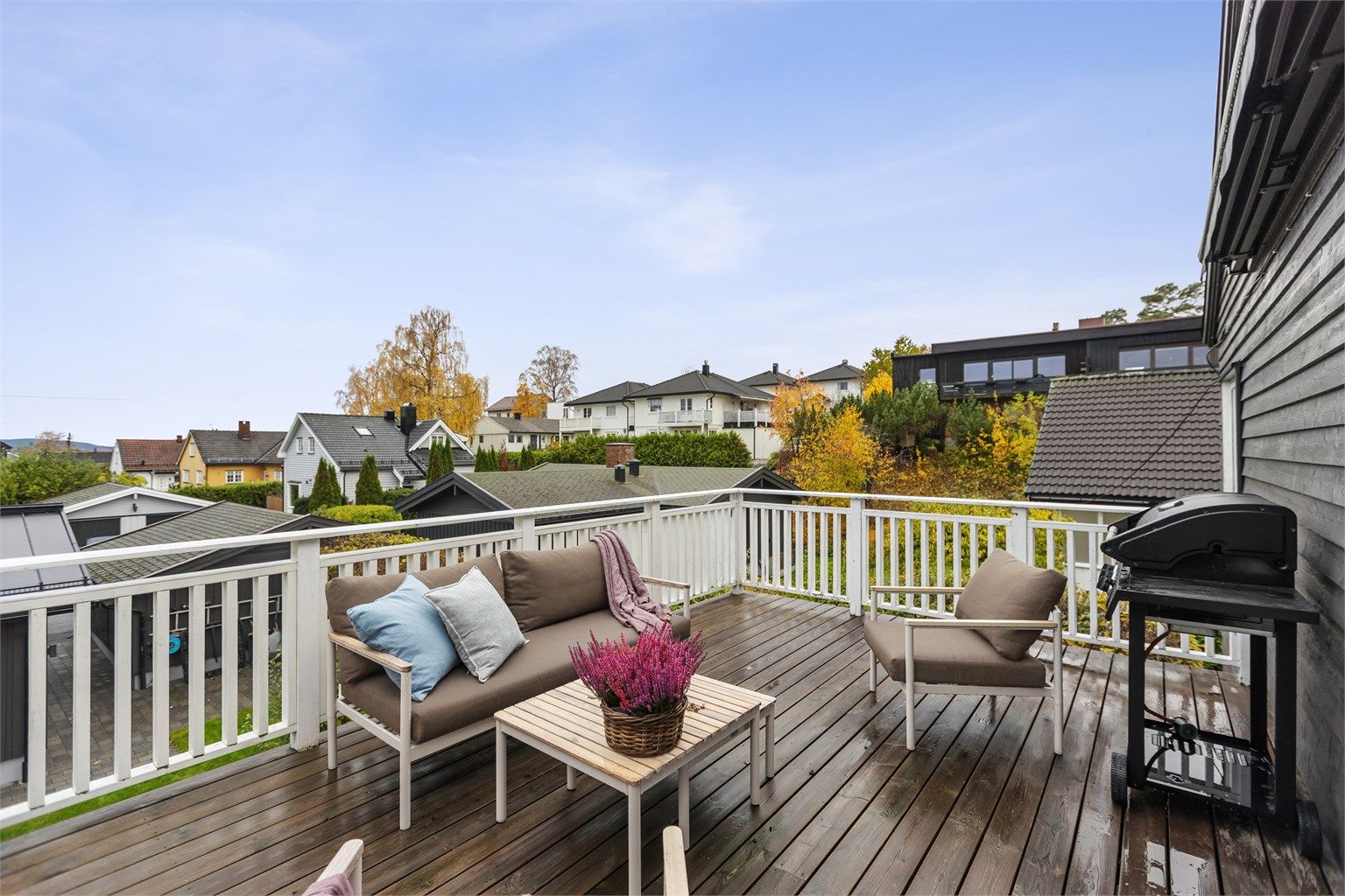 Utsyn over etablert villabebyggelse og grønne omgivelser fra terrassen.