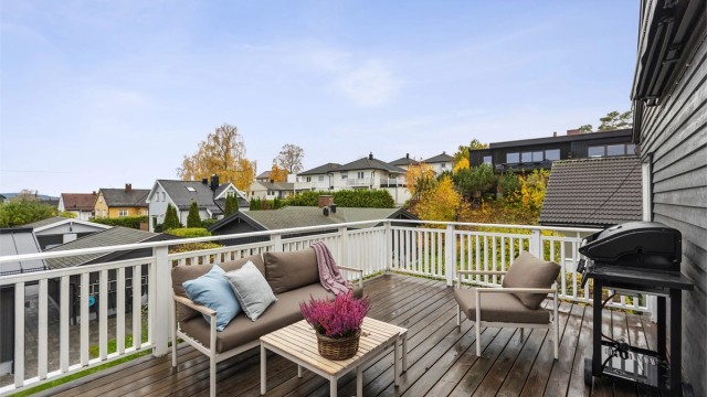 Utsyn over etablert villabebyggelse og grønne omgivelser fra terrassen.