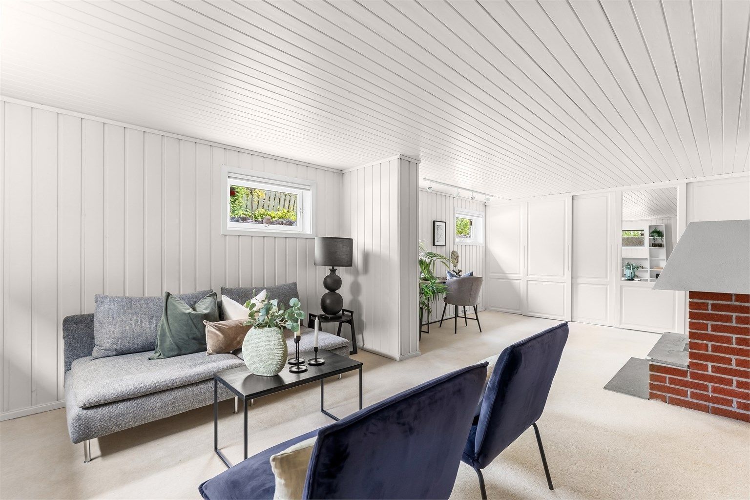 Malt panel på vegger og i tak gir en lys og trivelig kjellerstue.