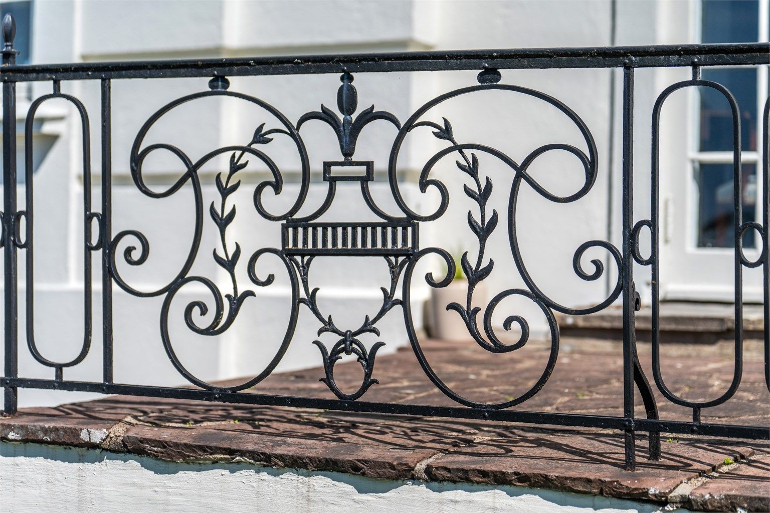 På den elegante terrassen som går langs hele langsiden av boligen er det et rekkverk i smijern og den deles av et bredt trappeløp ned til hagen. 
