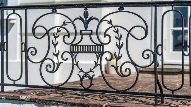 På den elegante terrassen som går langs hele langsiden av boligen er det et rekkverk i smijern og den deles av et bredt trappeløp ned til hagen.