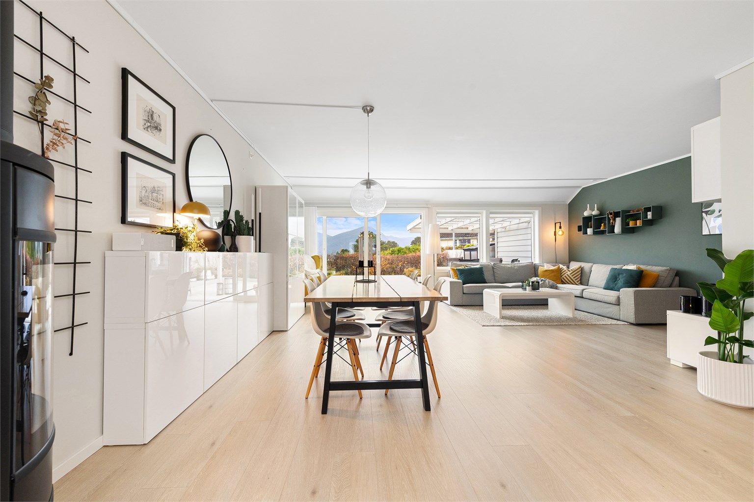 Romslig stue med store vinduer og utgang til terrasse