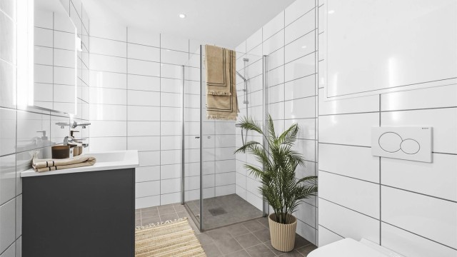 Flislagt baderom med opplegg for vaskemaskin.