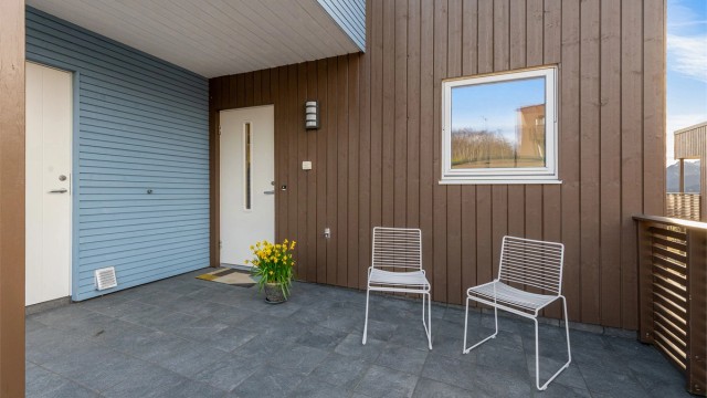 Overbygd inngangsparti som gir ly for vær og vind.
