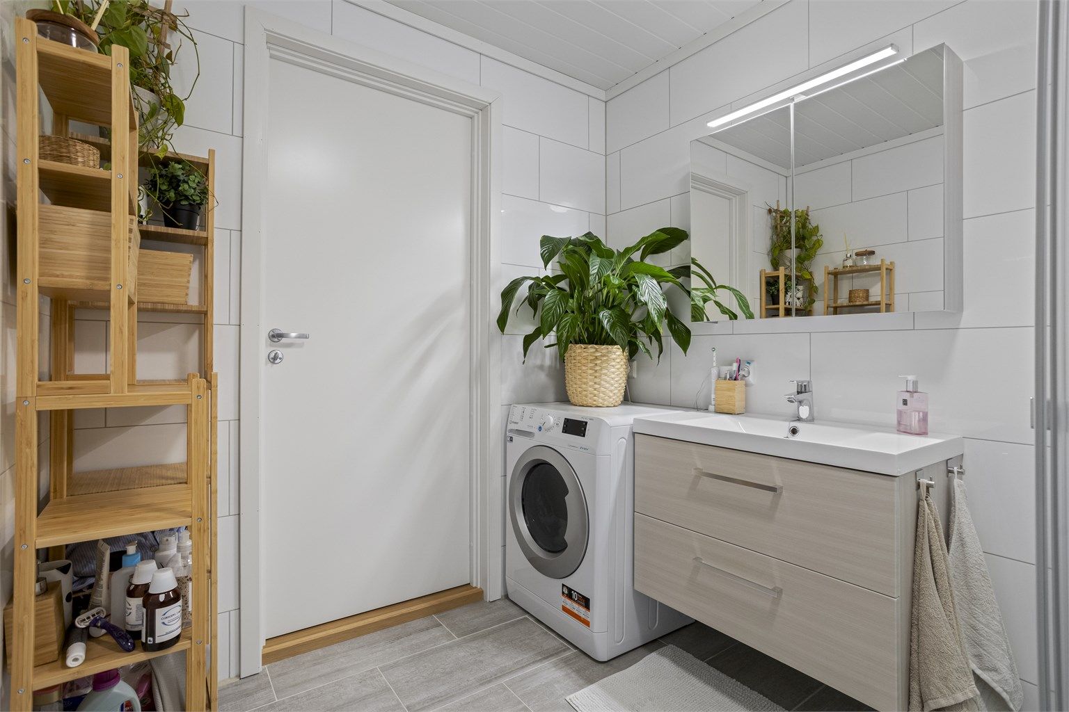 Rommet er utstyrt med vegghengt toalett, servantinnredning og opplegg for vaskemaskin.
