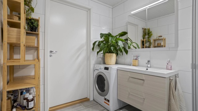 Rommet er utstyrt med vegghengt toalett, servantinnredning og opplegg for vaskemaskin.