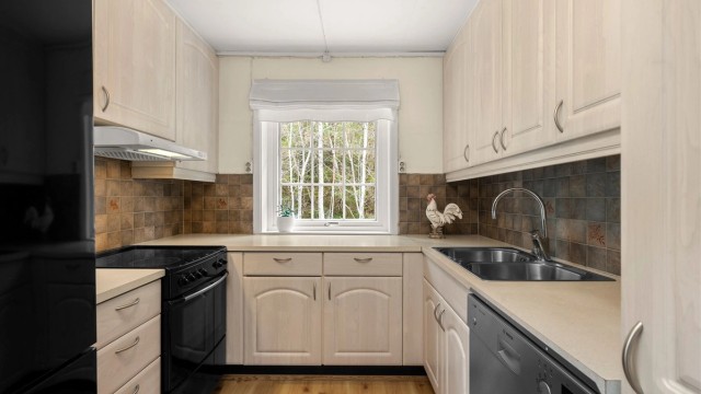 Funksjonelt kjøkken med lyse fronter, god arbeidsflyt og vindu som tilfører rommet behagelig dagslys.