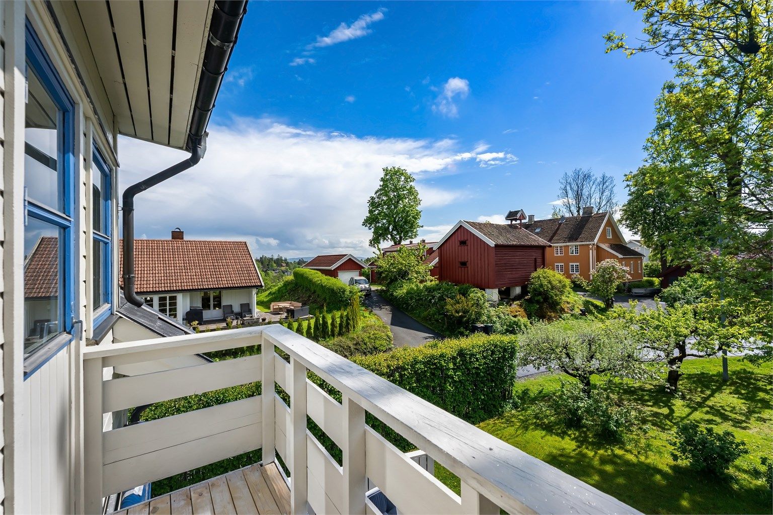 Utsyn mot et eldre stabbur og grønne omgivelser.