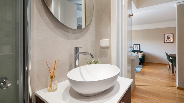 Badet er innredet med vegghengt toalett og et stilrent servantskap med speil med integrert bakbelysning som gir både god funksjonalitet og en behagelig romfølelse.