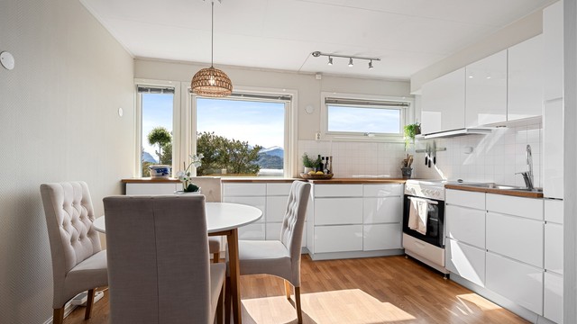 Kjøkkeninnredning fra Kvik med glatte, hvite fronter og benkeplate i heltre