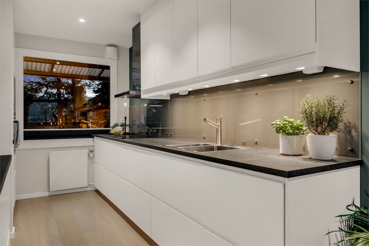 Kjøkkeninnredningen fra 2018 har glatte fronter og integrerte hvitevarer, inkludert stekeovn og mikrobølgeovn.