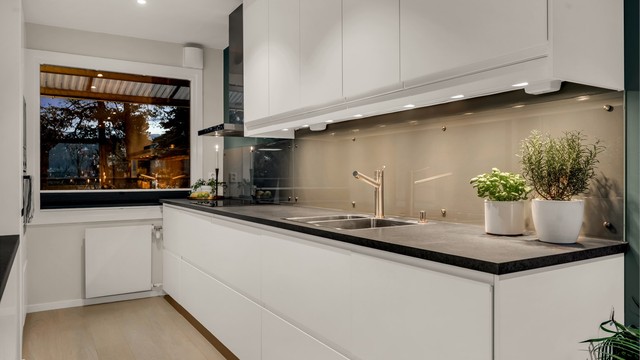 Kjøkkeninnredningen fra 2018 har glatte fronter og integrerte hvitevarer, inkludert stekeovn og mikrobølgeovn.