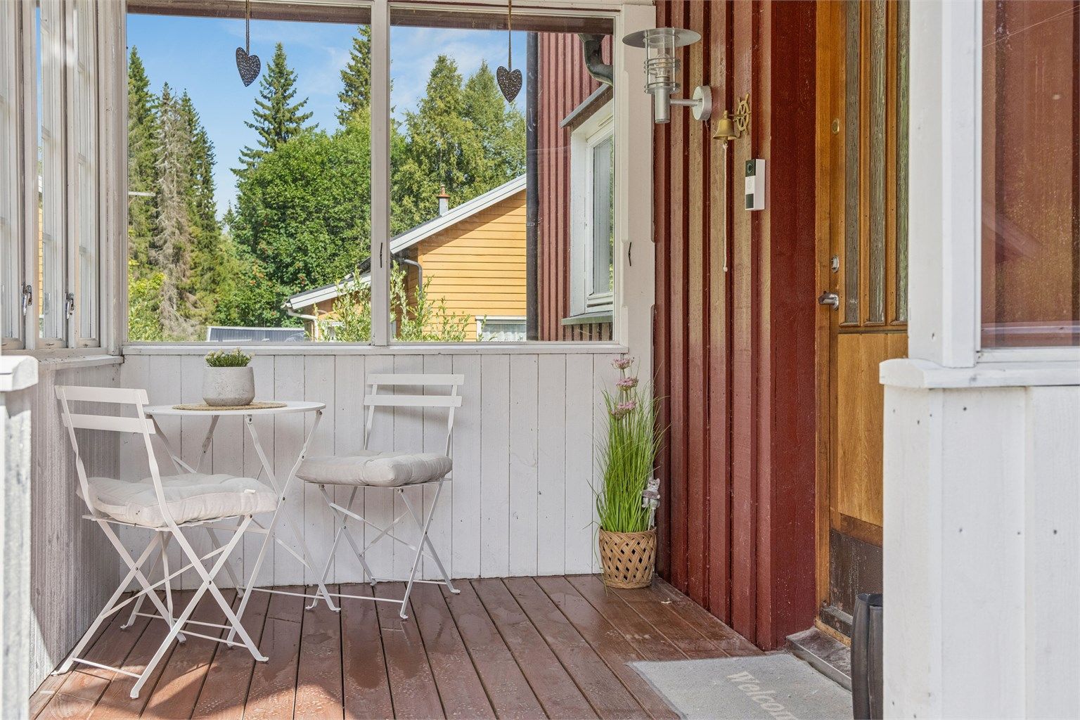 Koselig innglasset inngangsparti med plass til en liten sittegruppe.