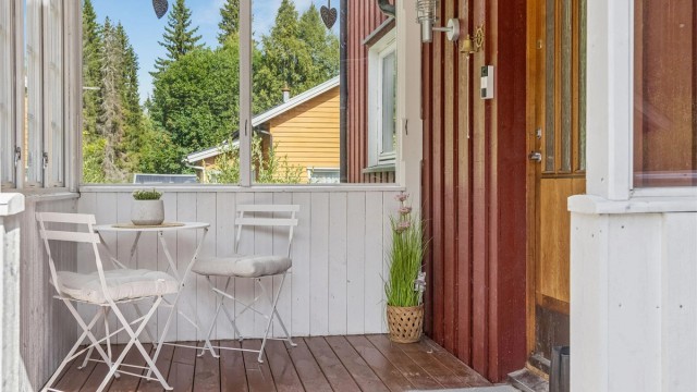 Koselig innglasset inngangsparti med plass til en liten sittegruppe.