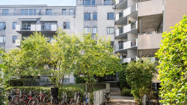 En skjermet og grønn bakgård med sykkelparkering skaper rolige omgivelser midt i byen.