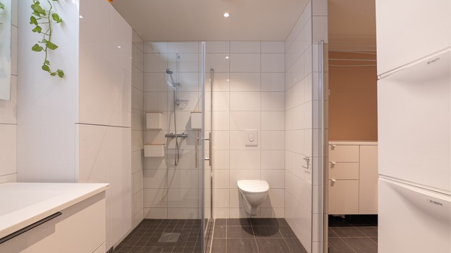Arealkrevende vaskemaskin og tørketrommel har dedikert plass i vaskeromsdelen av badet.