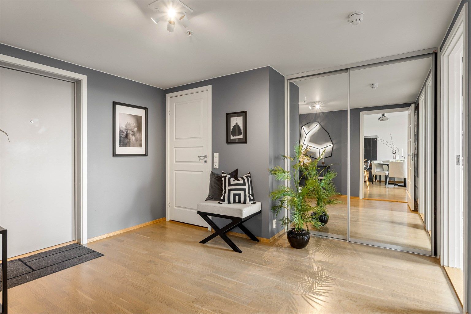 Romslig entré med skyvedørsgarderobe med speilfronter for rikelig med oppbevaring.