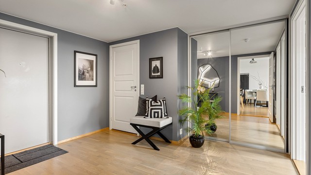 Romslig entré med skyvedørsgarderobe med speilfronter for rikelig med oppbevaring.