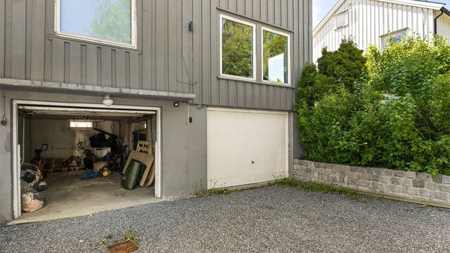 Leiligheten har en medfølgende integrert garasje (midterste) i bygningens kjeller.