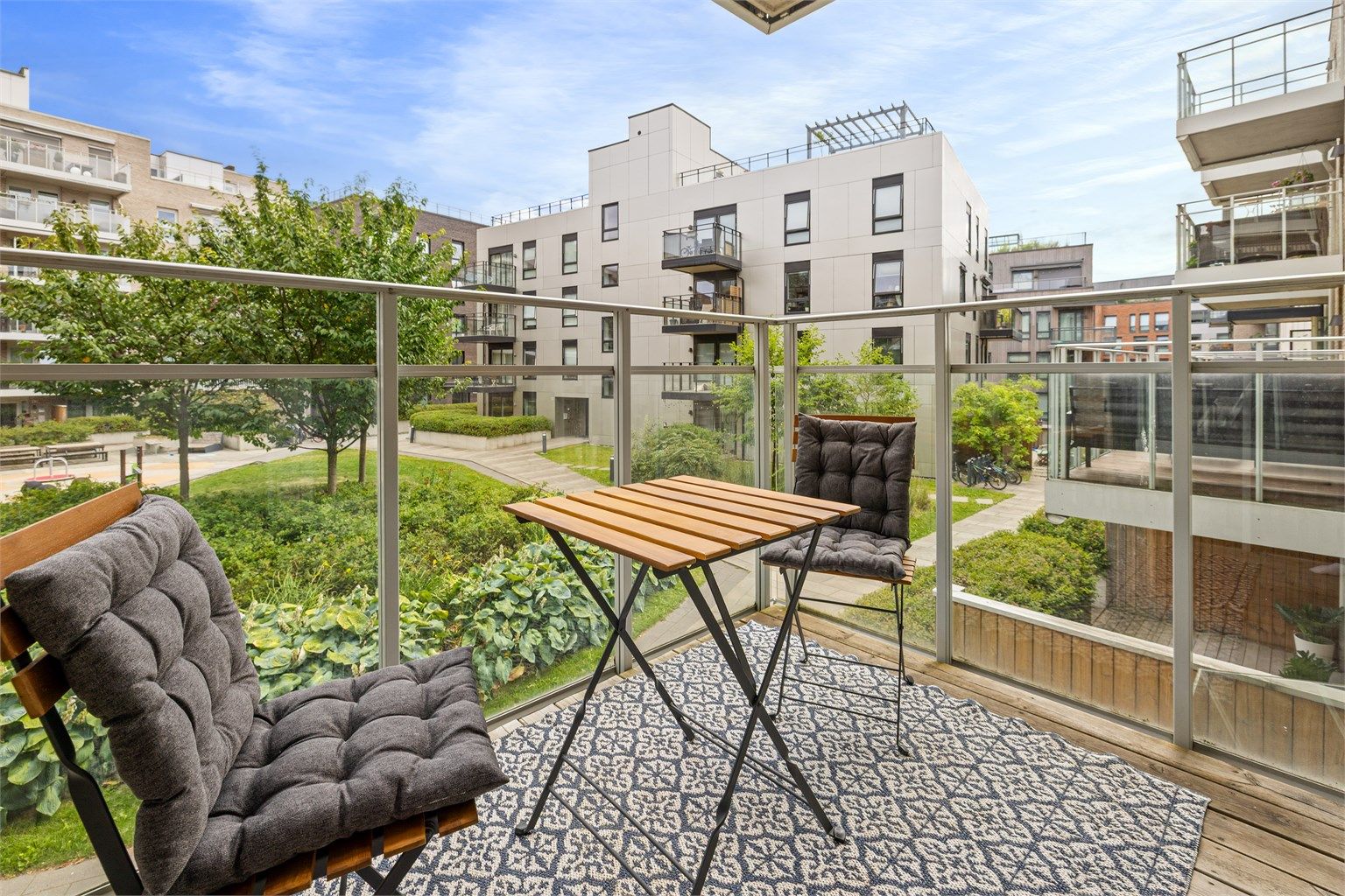 Balkongen vender mot et pent opparbeidet gårdsrom og byr på en rolig og hyggelig uteplass.