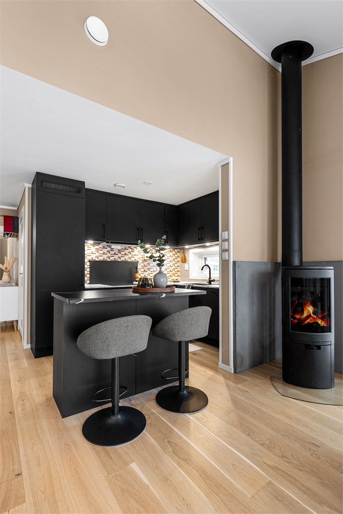 Åpen kjøkkenløsning. Kjøkkeninnredning fra byggeår. Kjøkkenøy fra 2023 med benkeplate i komposittstein.