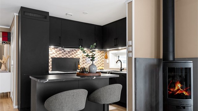 Åpen kjøkkenløsning. Kjøkkeninnredning fra byggeår. Kjøkkenøy fra 2023 med benkeplate i komposittstein.