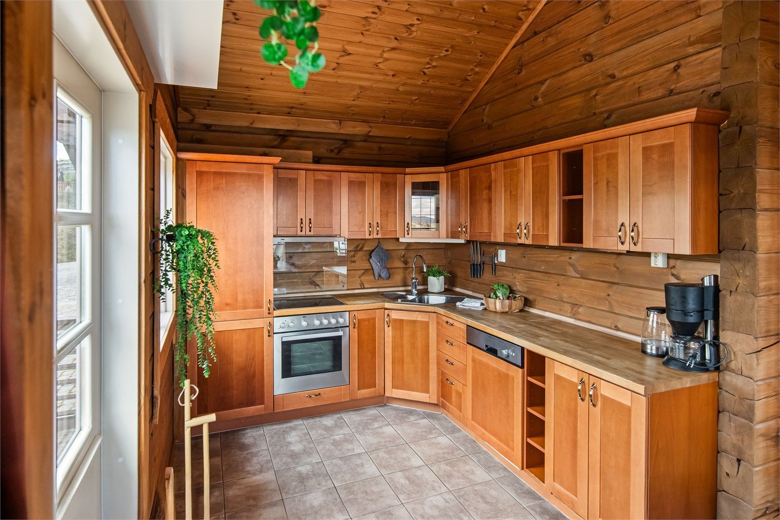 Kirsebærfarget kjøkken fra byggeår, 2010. Integrerte hvitevarer.