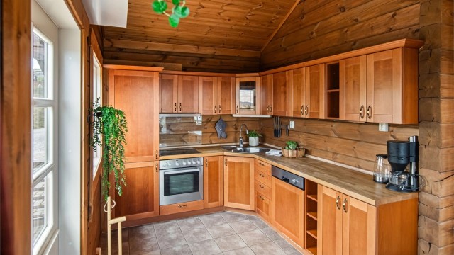 Kirsebærfarget kjøkken fra byggeår, 2010. Integrerte hvitevarer