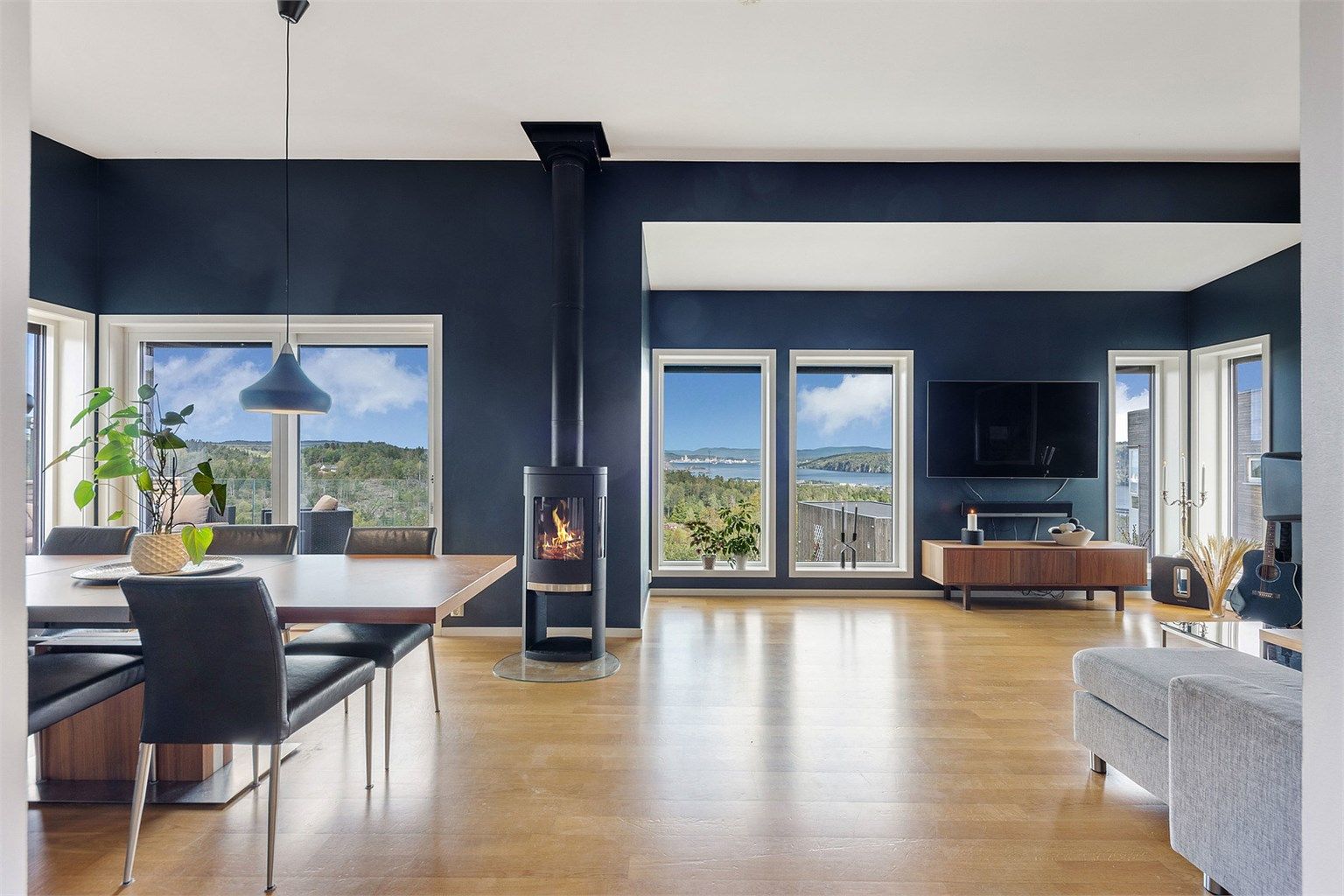 Stuen har store vindusflater som gir rikelig med lys og rammer inn utsikten.