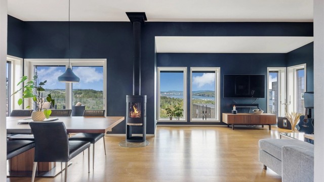 Stuen har store vindusflater som gir rikelig med lys og rammer inn utsikten.