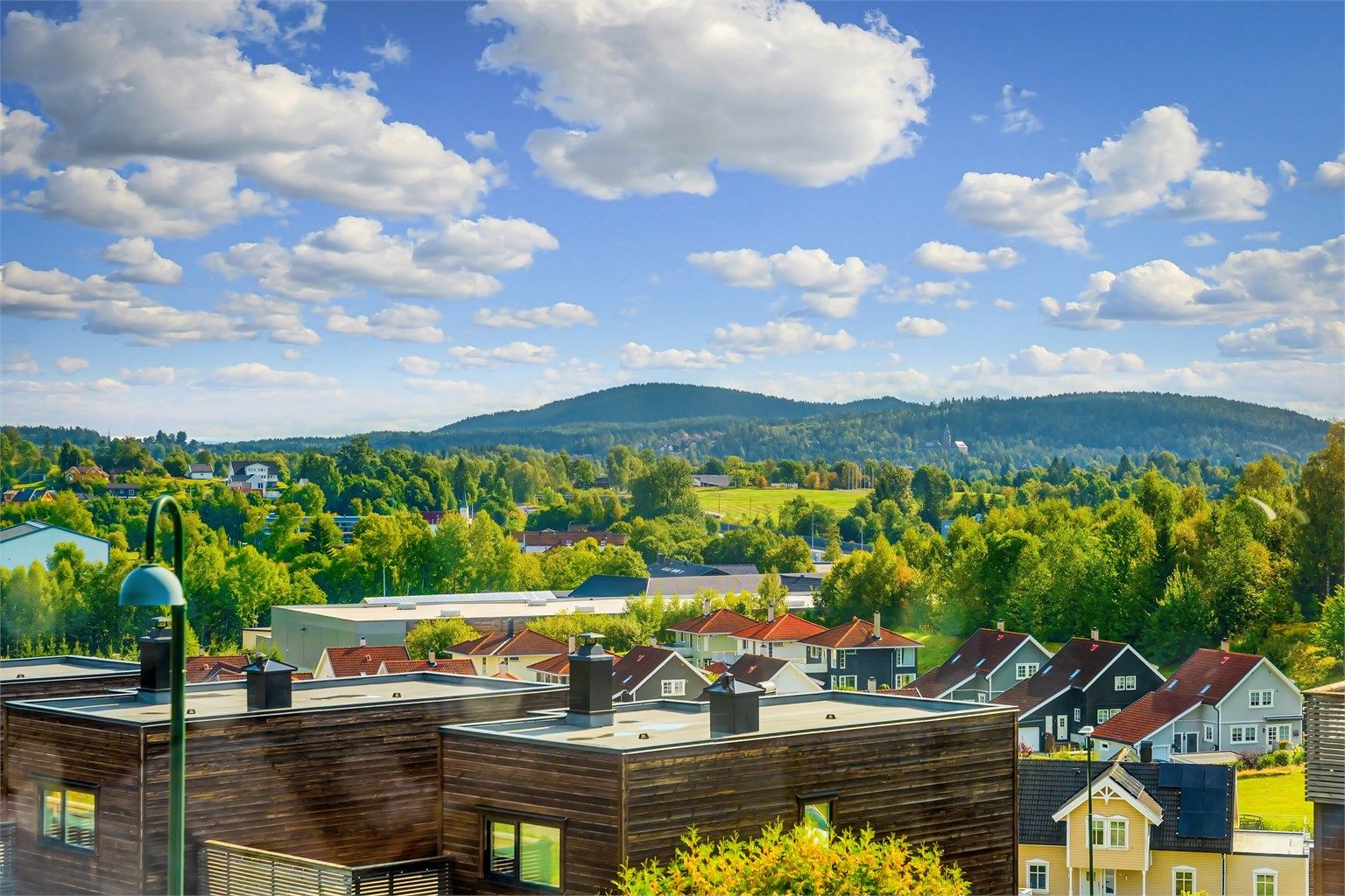Moderne rekkehus fra 2014 over fire plan med stor takterrasse og integrert garasje.