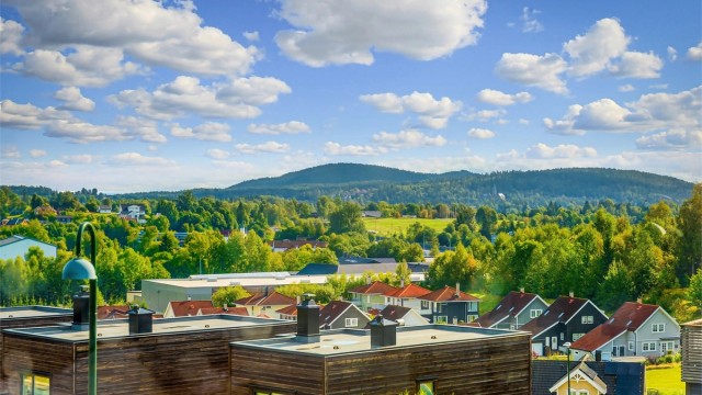 Moderne rekkehus fra 2014 over fire plan med stor takterrasse og integrert garasje.