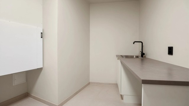 Eget vaskerom med flislagt gulv, gulvvarme, utslagsvask og opplegg for vaskemaskin.