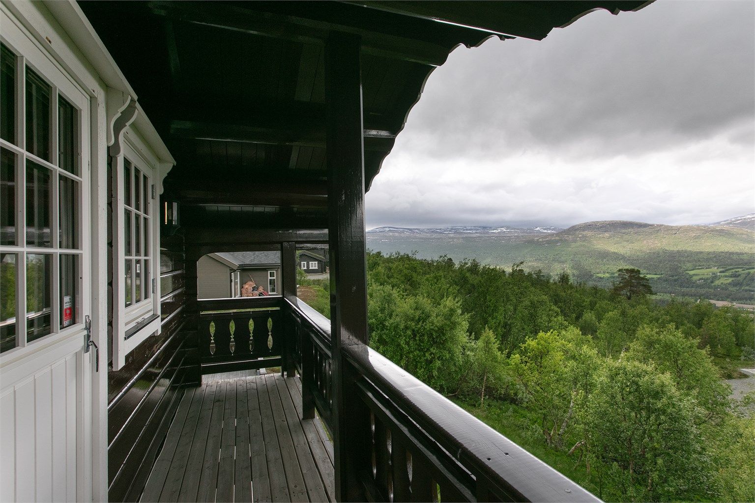 Fra balkongen er det vidstrakt utsikt over nærområdet og fjellene.