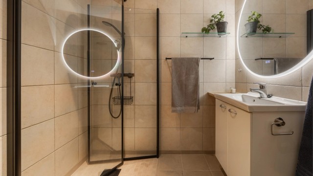 Dusjhjørnet har praktiske, innfellbare dører i glass som frigjør gulvplass.