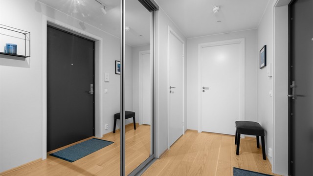 Romslig hall med skyvedørsgarderobe for god oppbevaring av yttertøy.