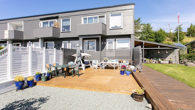 Enderekkehuset har treterrasser på terreng og gangpassasje i tre til overbygget.