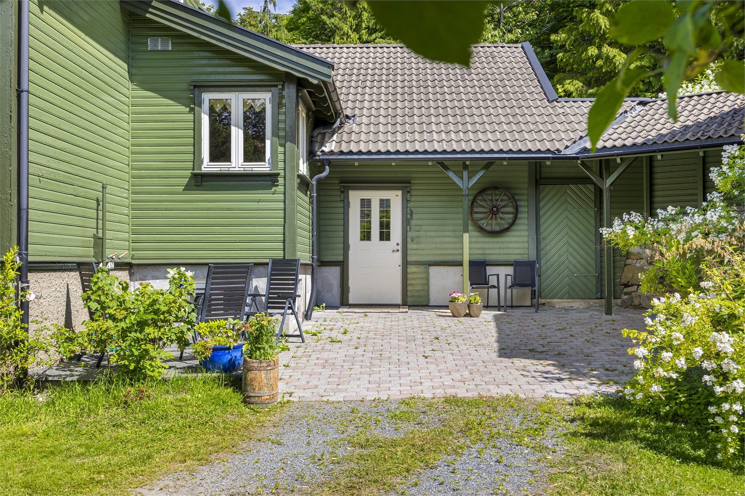 Uteplass med belegningsstein ved tilbygget fra 2000.