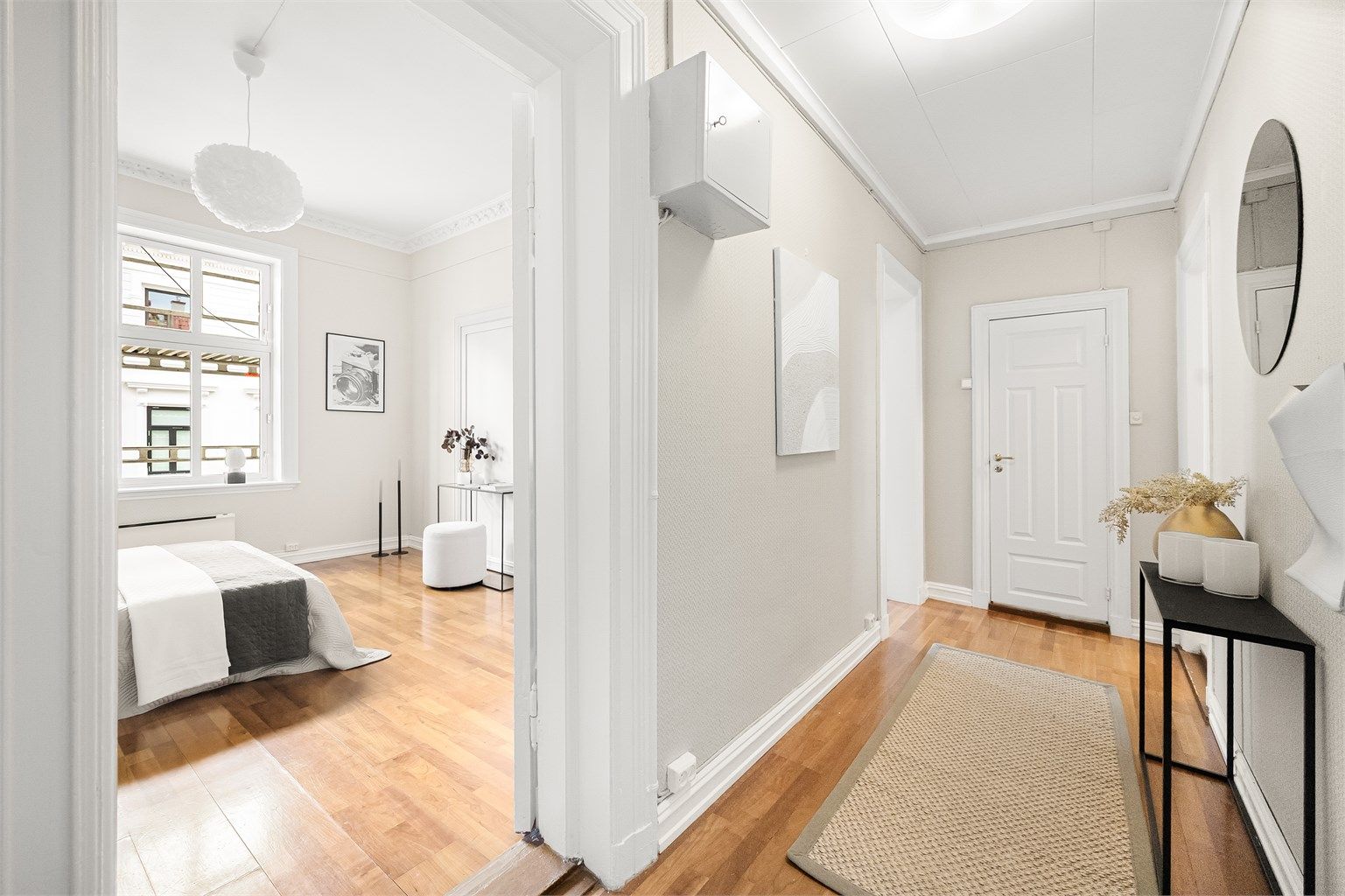 Romslig entré med plass for klesoppheng og oppbevaring av sko samt praktisk, innebygget garderobe i enden av entréen.