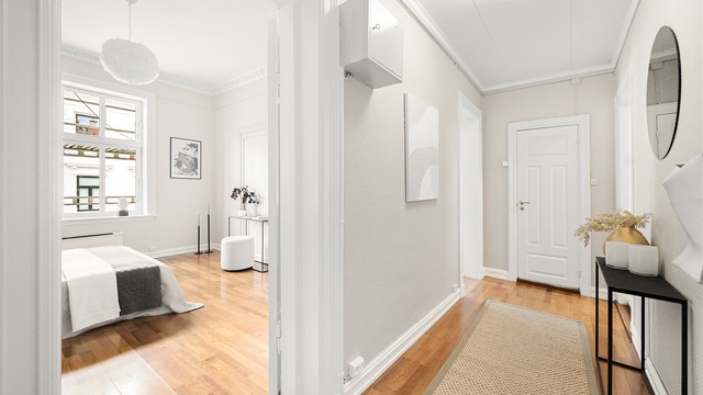 Romslig entré med plass for klesoppheng og oppbevaring av sko samt praktisk, innebygget garderobe i enden av entréen.