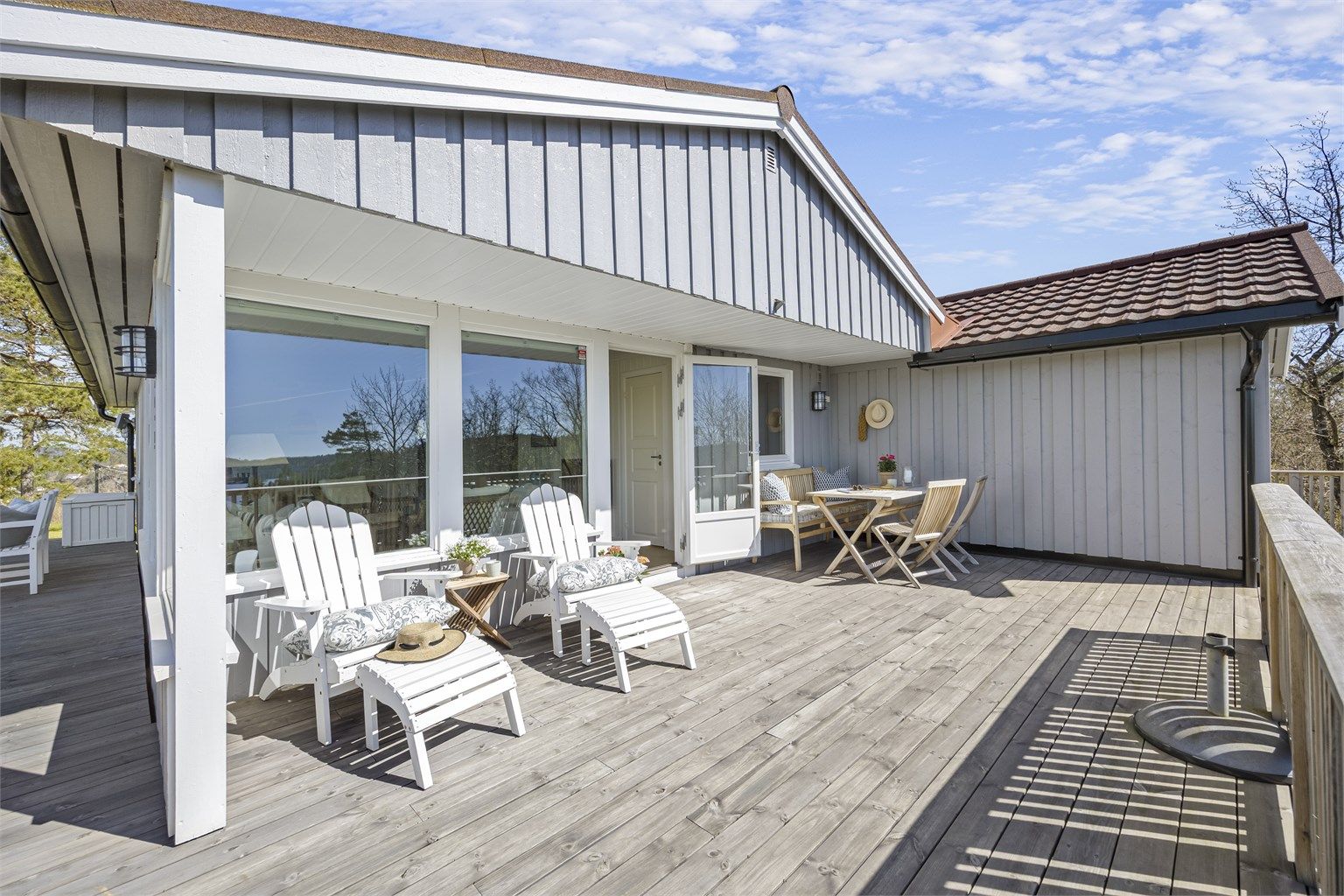 Fasaden er kledd med stående trekledning, og taket har takplater fra 2021 på tilbygget.